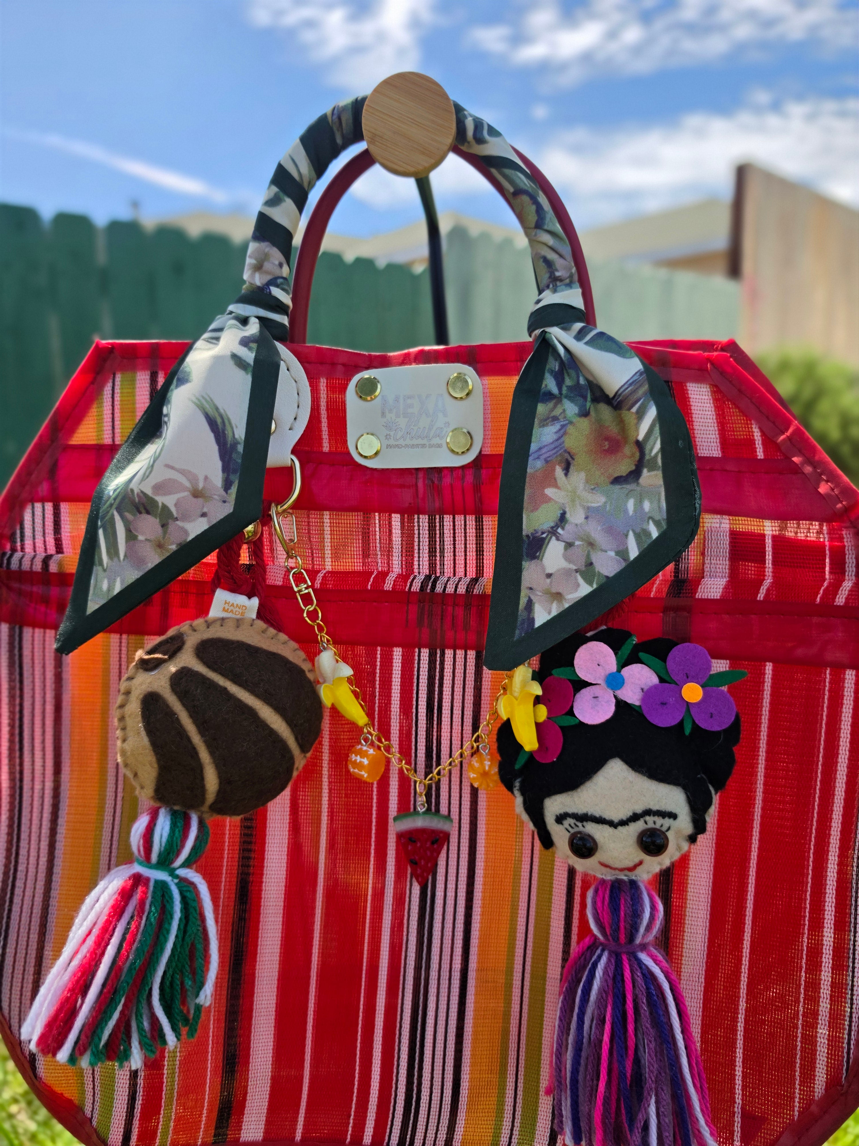 Detalle de asas con pañuelo floral verde y charm de concha tejido