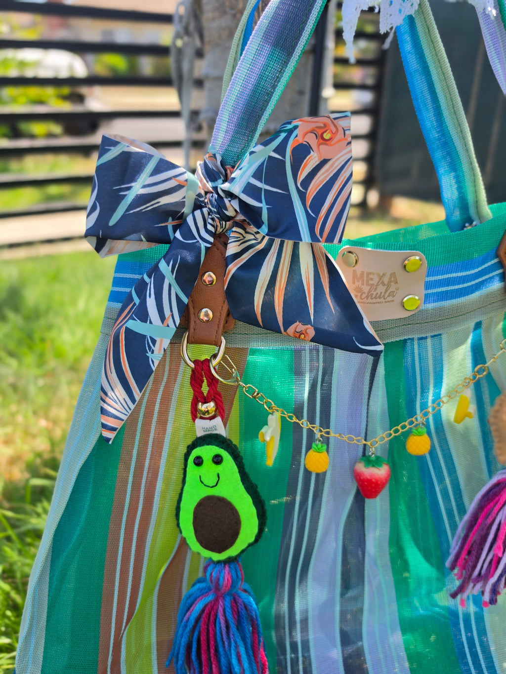 Detalle de asas de piel y moño tropical azul marino en bolsa de mercado mexicana artesanal