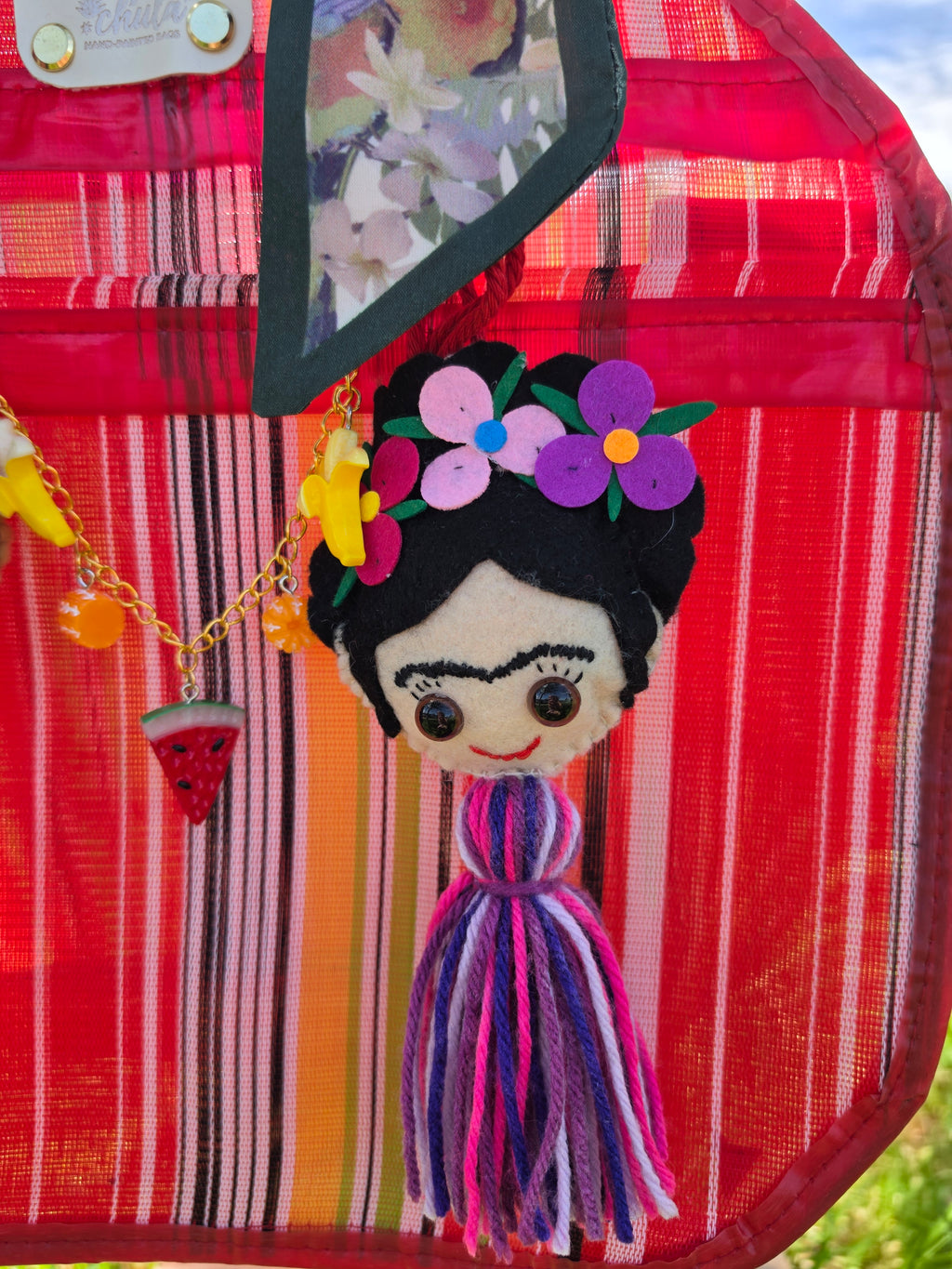 Muñeca Frida Kahlo de fieltro con corona de flores rosas y moradas