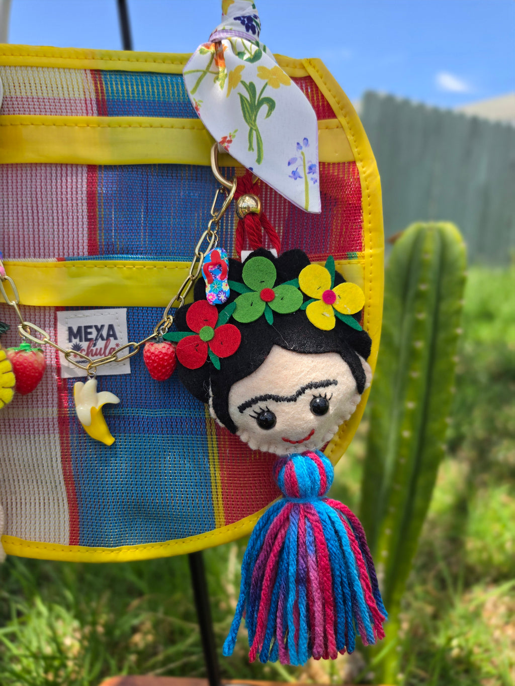 Muñeca Frida Kahlo de fieltro hecha a mano colgando de bolsa mexicana