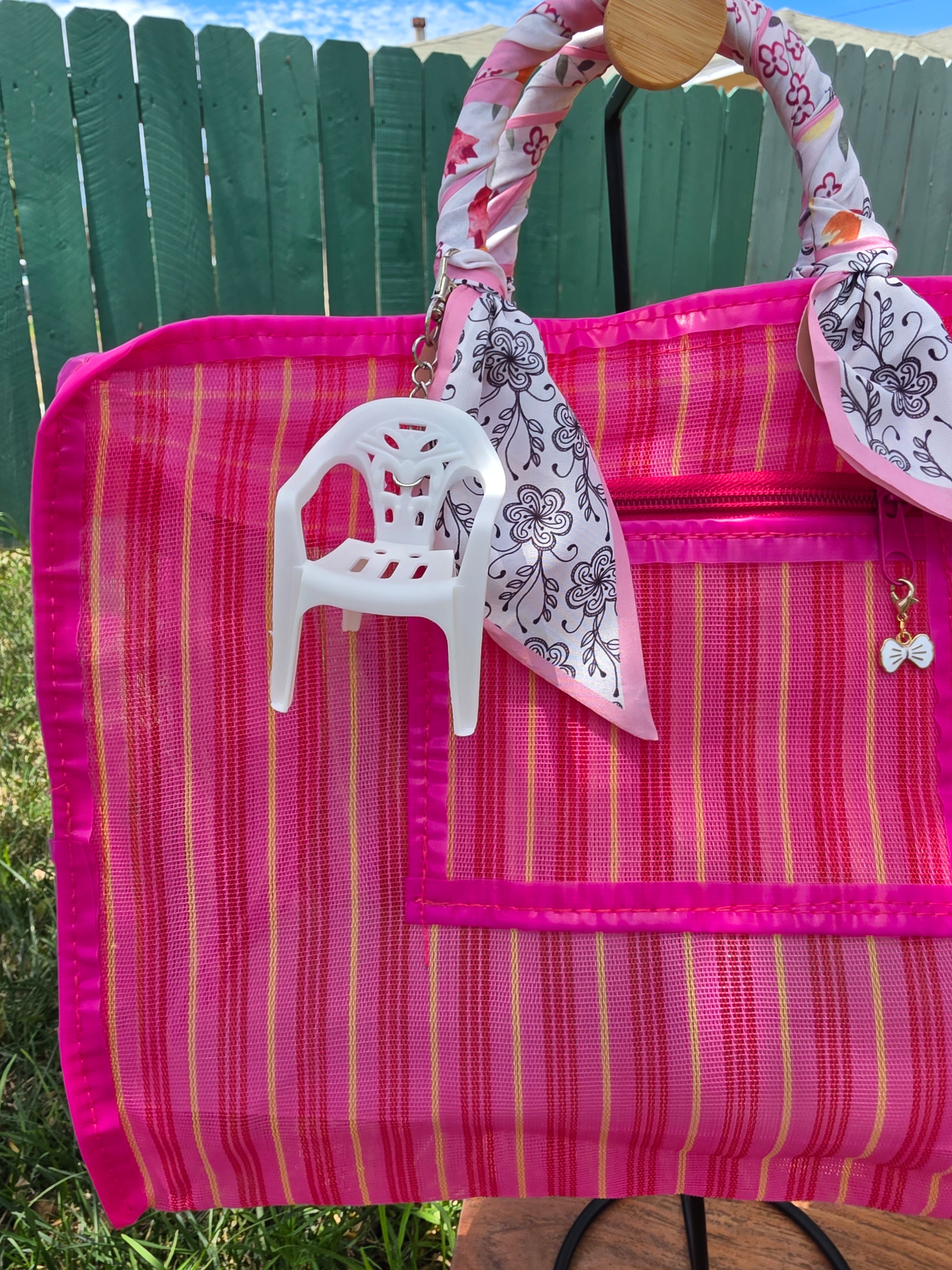 Charm de sillita blanca colgando de asa de bolsa mexicana rosa