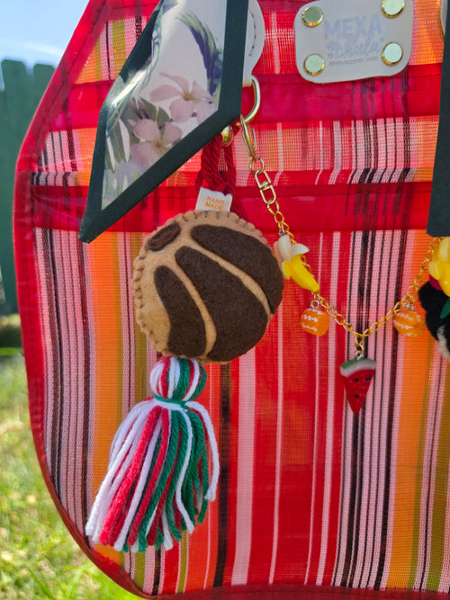 Charm de concha de pan dulce en fieltro con borla tricolor