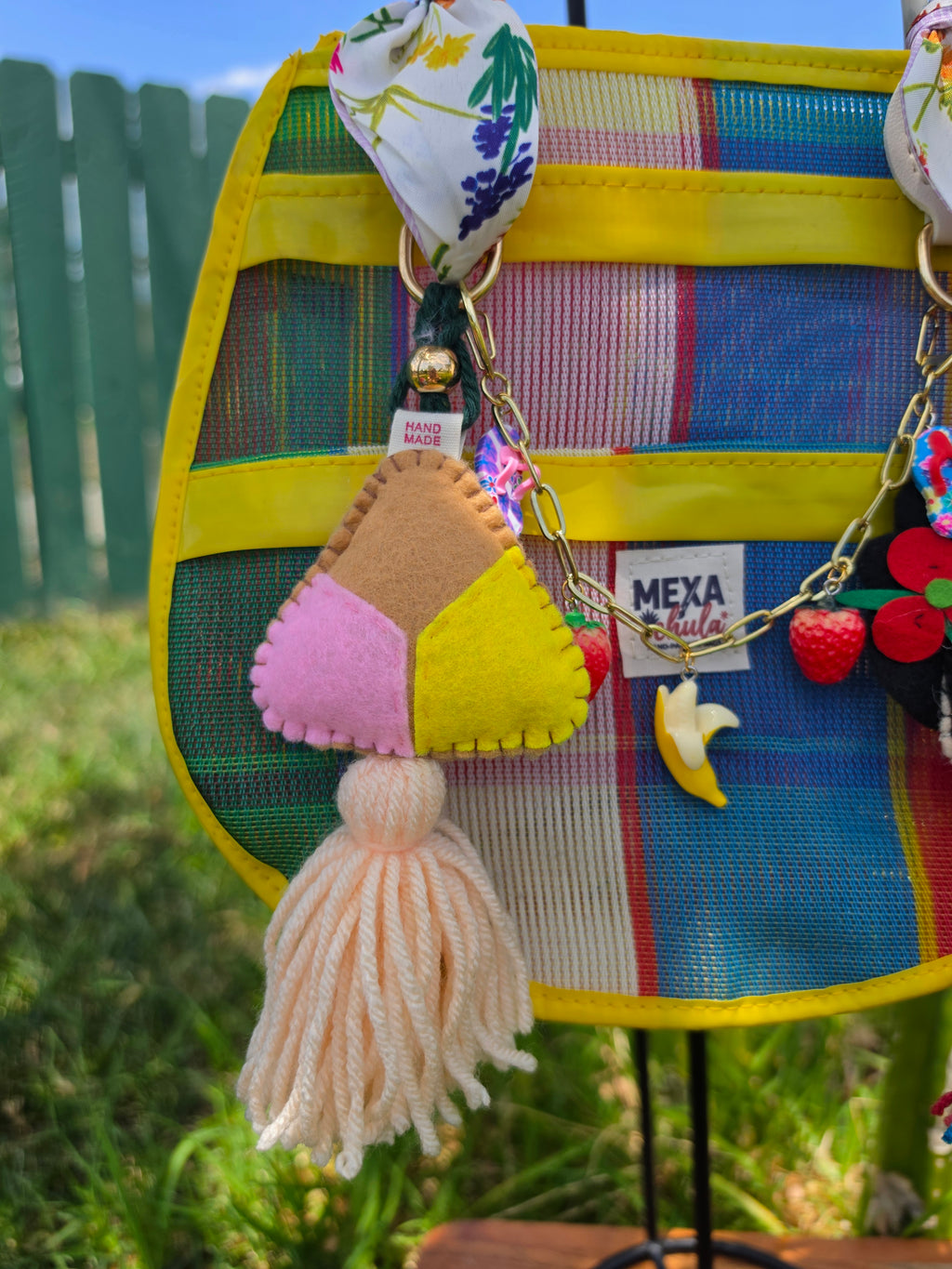 Detalle de charms artesanales: dulce de coco, fresa y plátano en bolsa mexicana