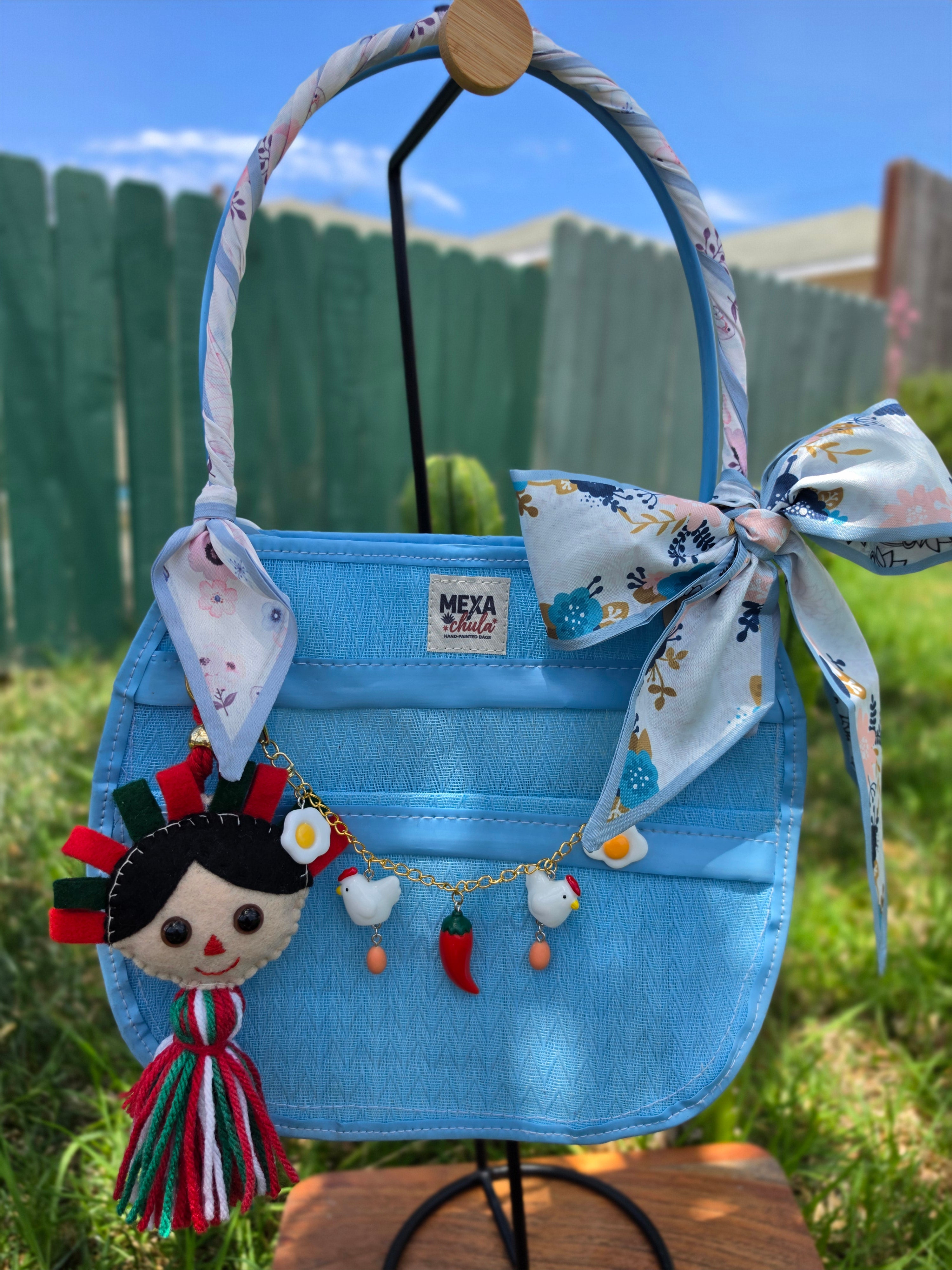 Muñeca Frida Kahlo de fieltro hecha a mano colgando de bolsa mexicana