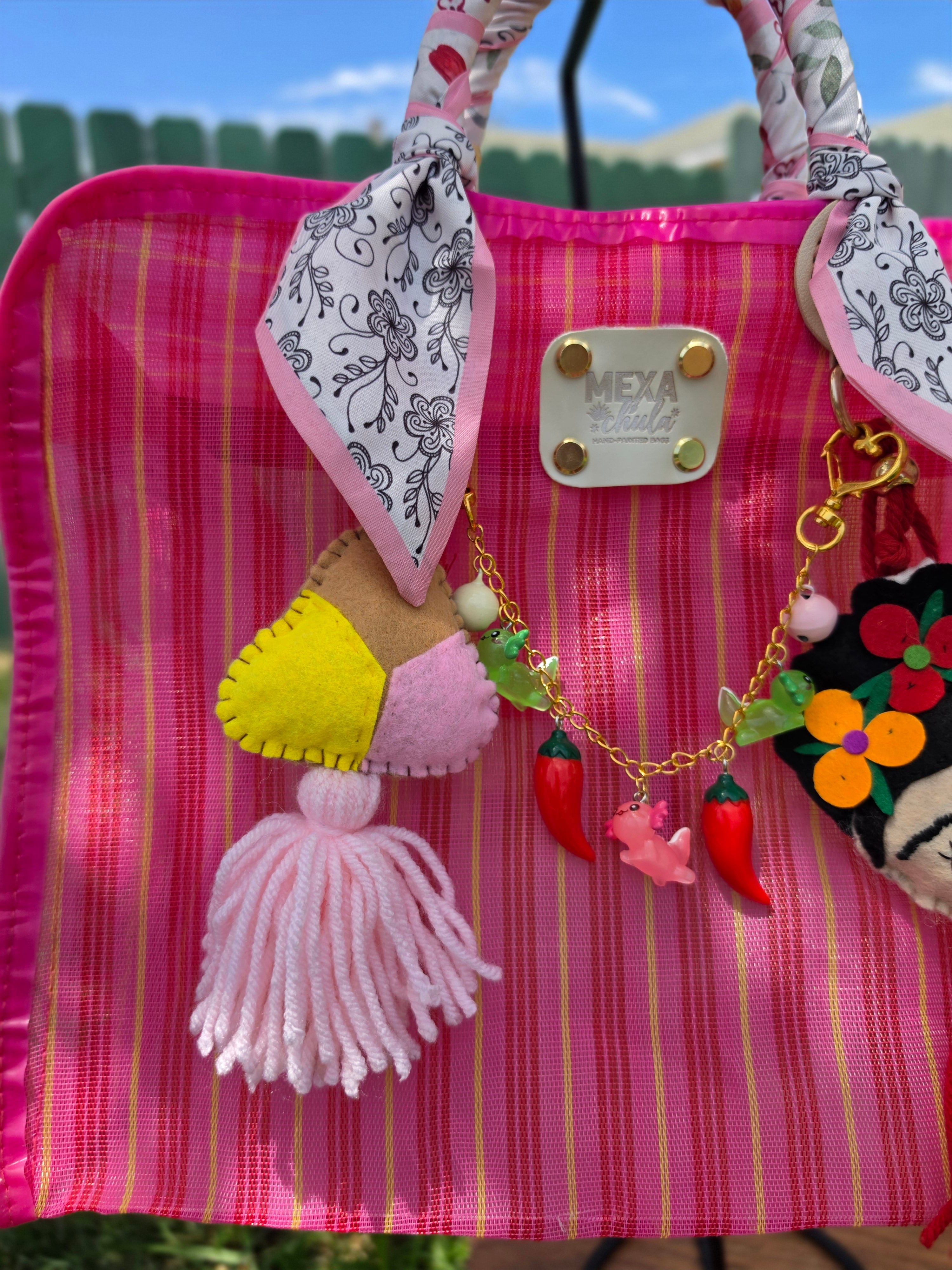 Detalle de charm de dulce en fieltro rosa, amarillo y tan con borla