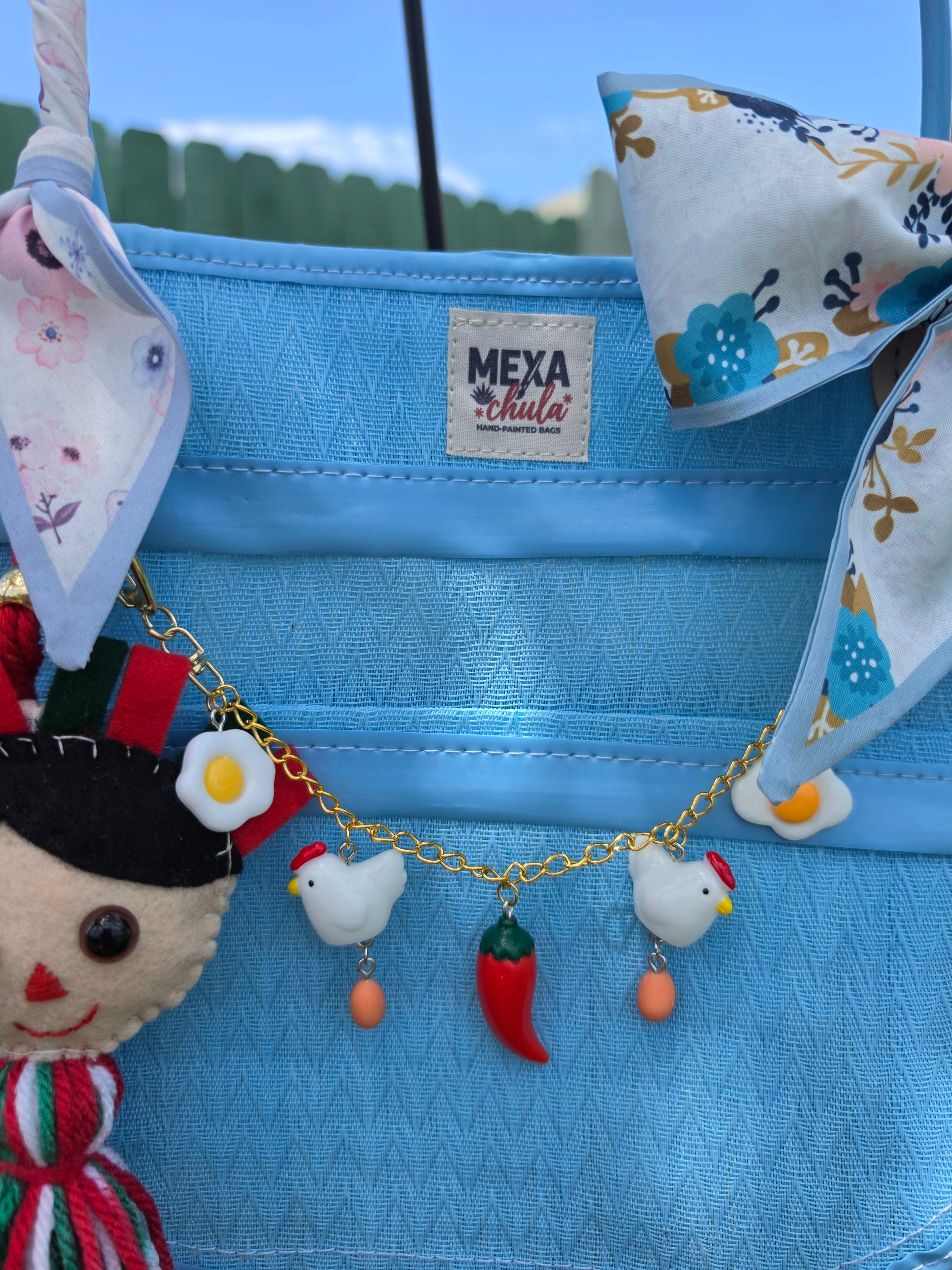 Detalle de charms artesanales: dulce de coco, fresa y plátano en bolsa mexicana