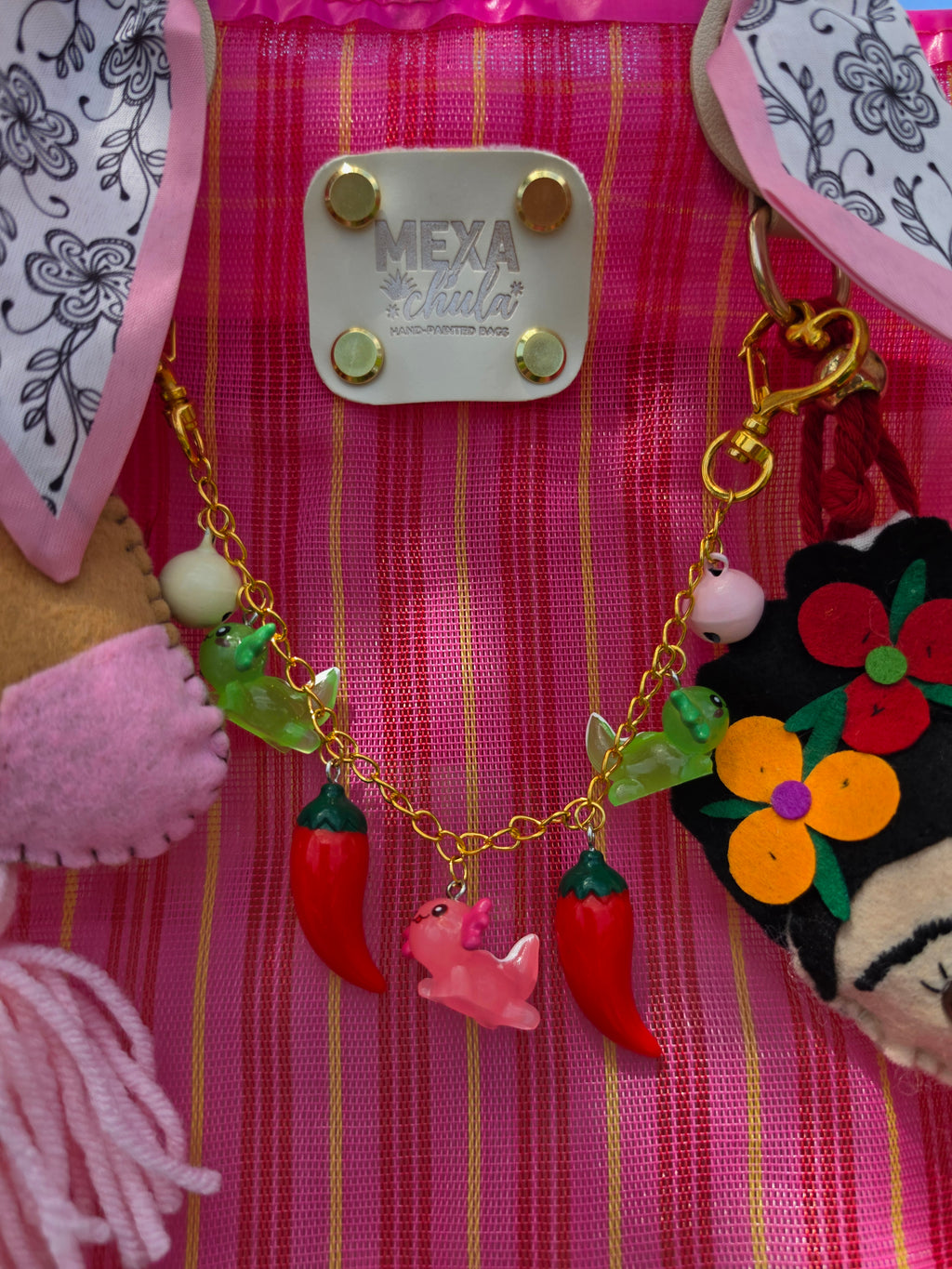 Cadena con charms de chiles, ranitas y dragoncito rosa en bolsa mexicana