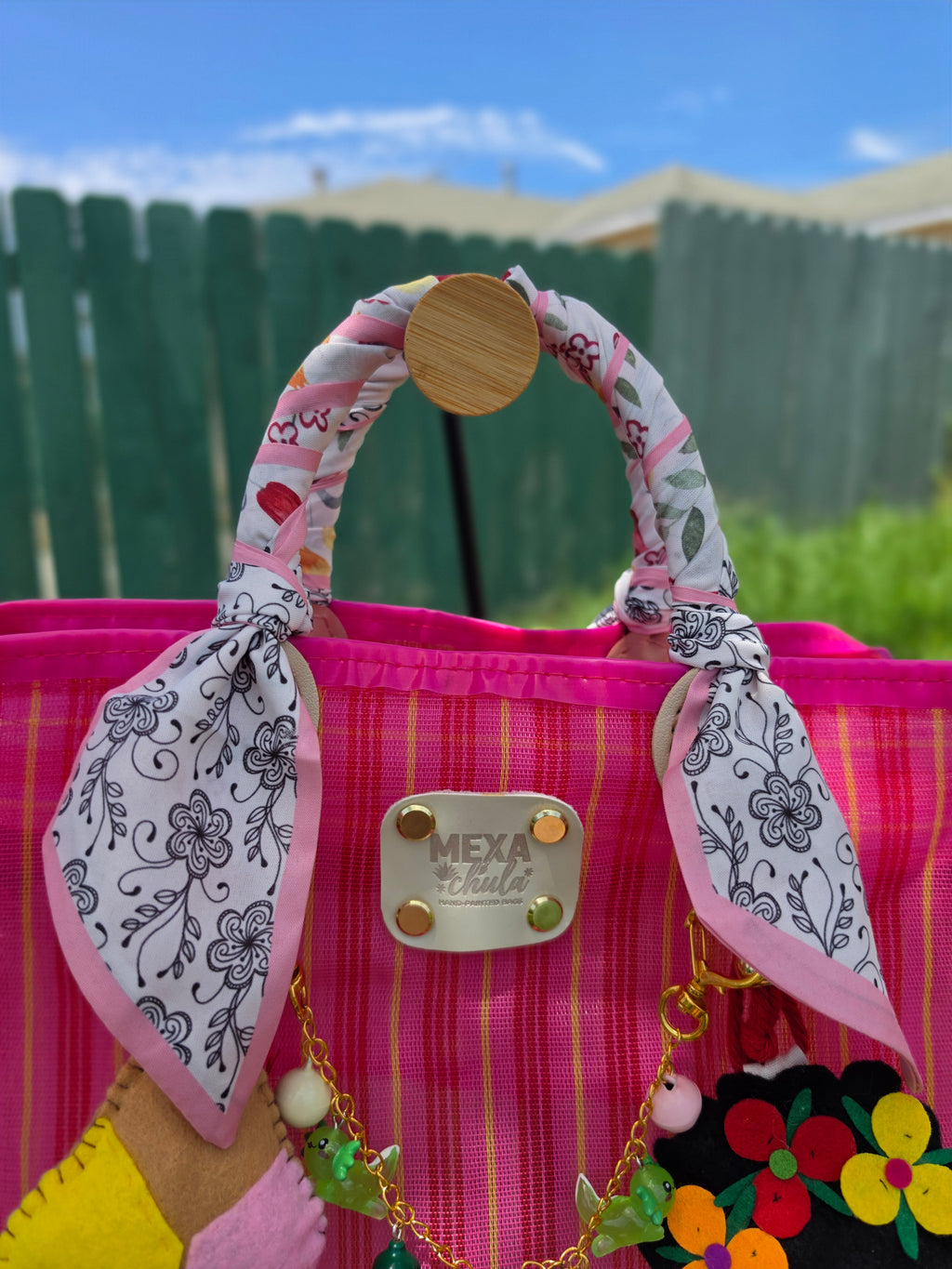 Detalle de pañuelo de listón floral anudado a mano en bolsa mexicana