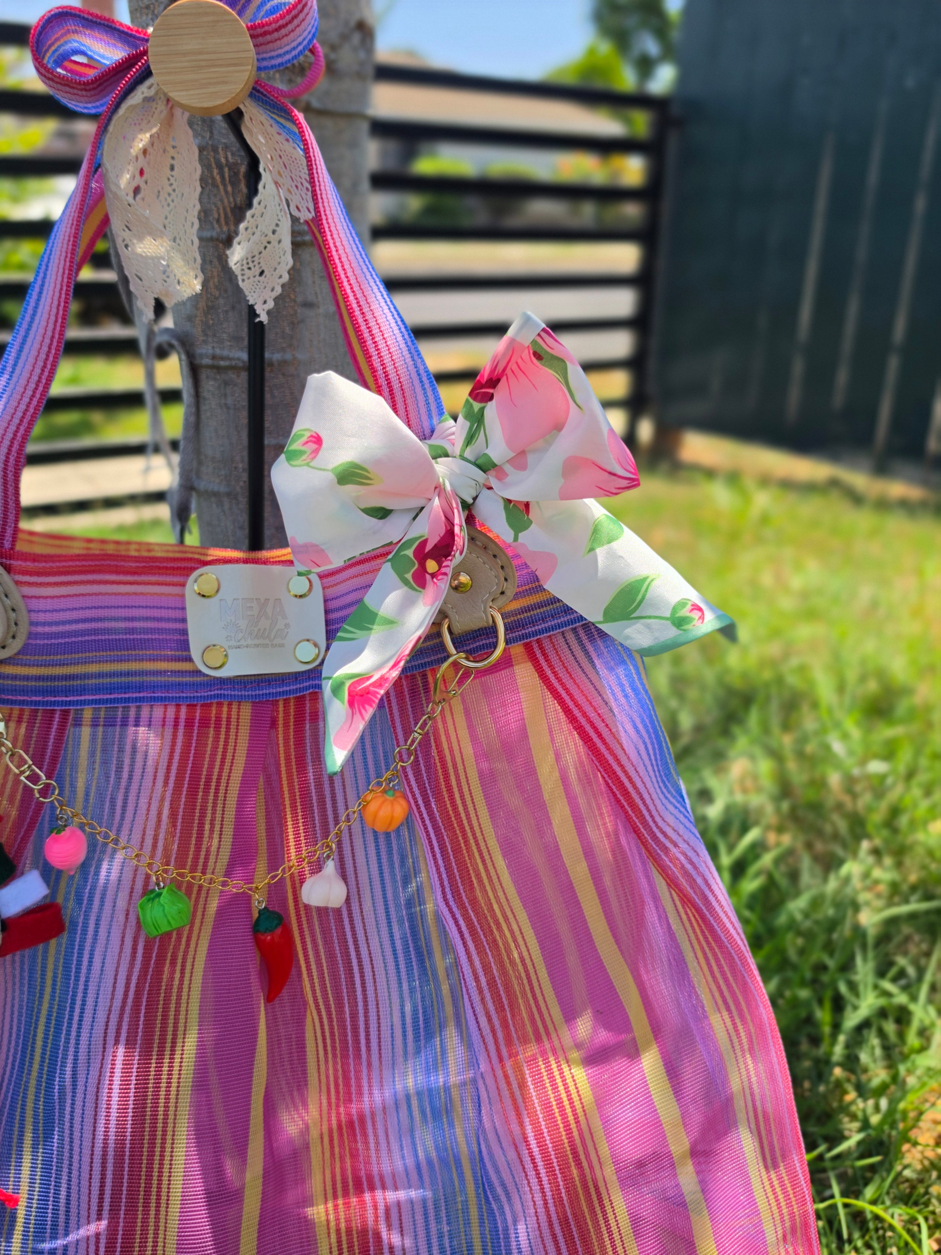 Detalle del moño floral rosa y la placa MEXA Chula en bolsa de mercado mexicana