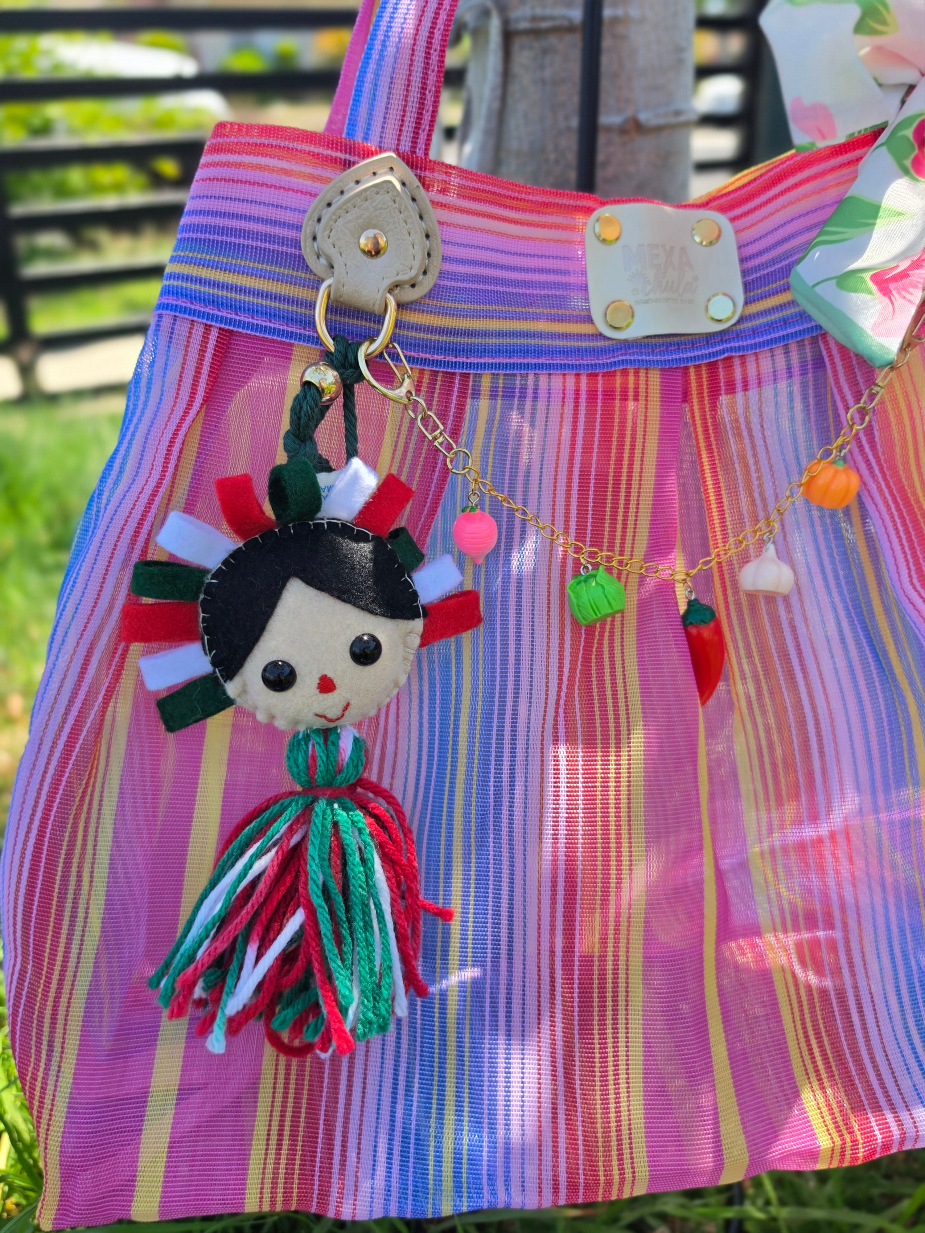 Charm de muñequita con penacho tricolor y borla de estambre en bolsa de mercado mexicana hecha a mano