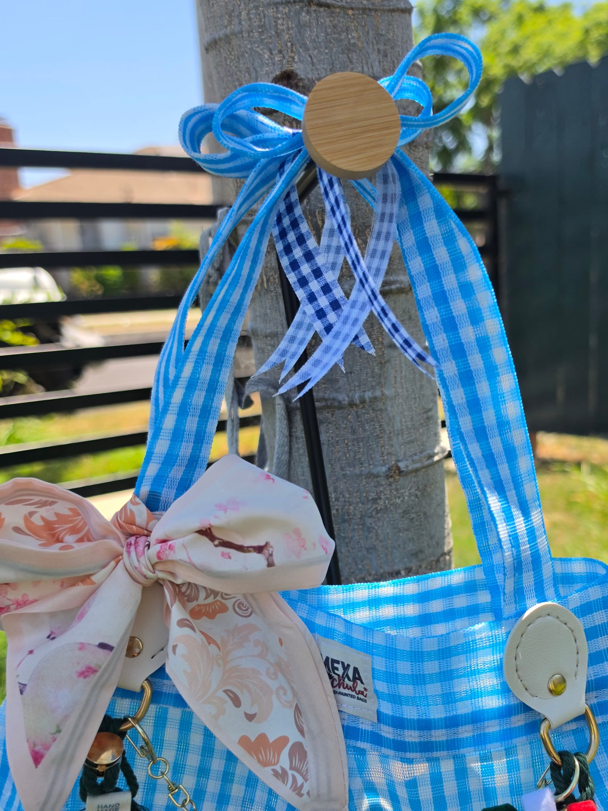 Detalle del moño floral rosa y cadena de charms de dulces en bolsa de mercado mexicana hecha a mano