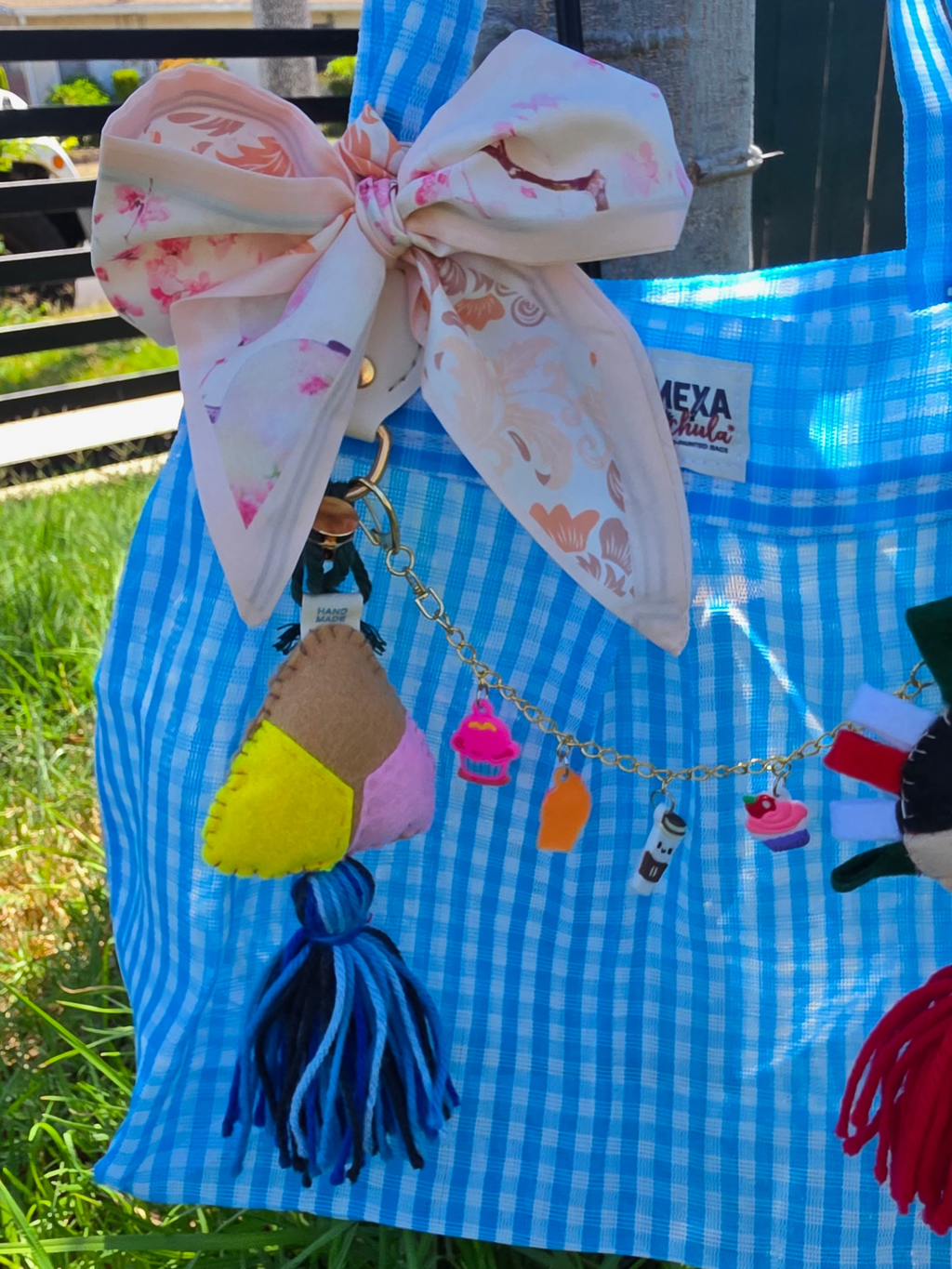 Bolsa de mercado mexicana con charm de concha de fieltro y cadena de dulces charms colgada al aire libre