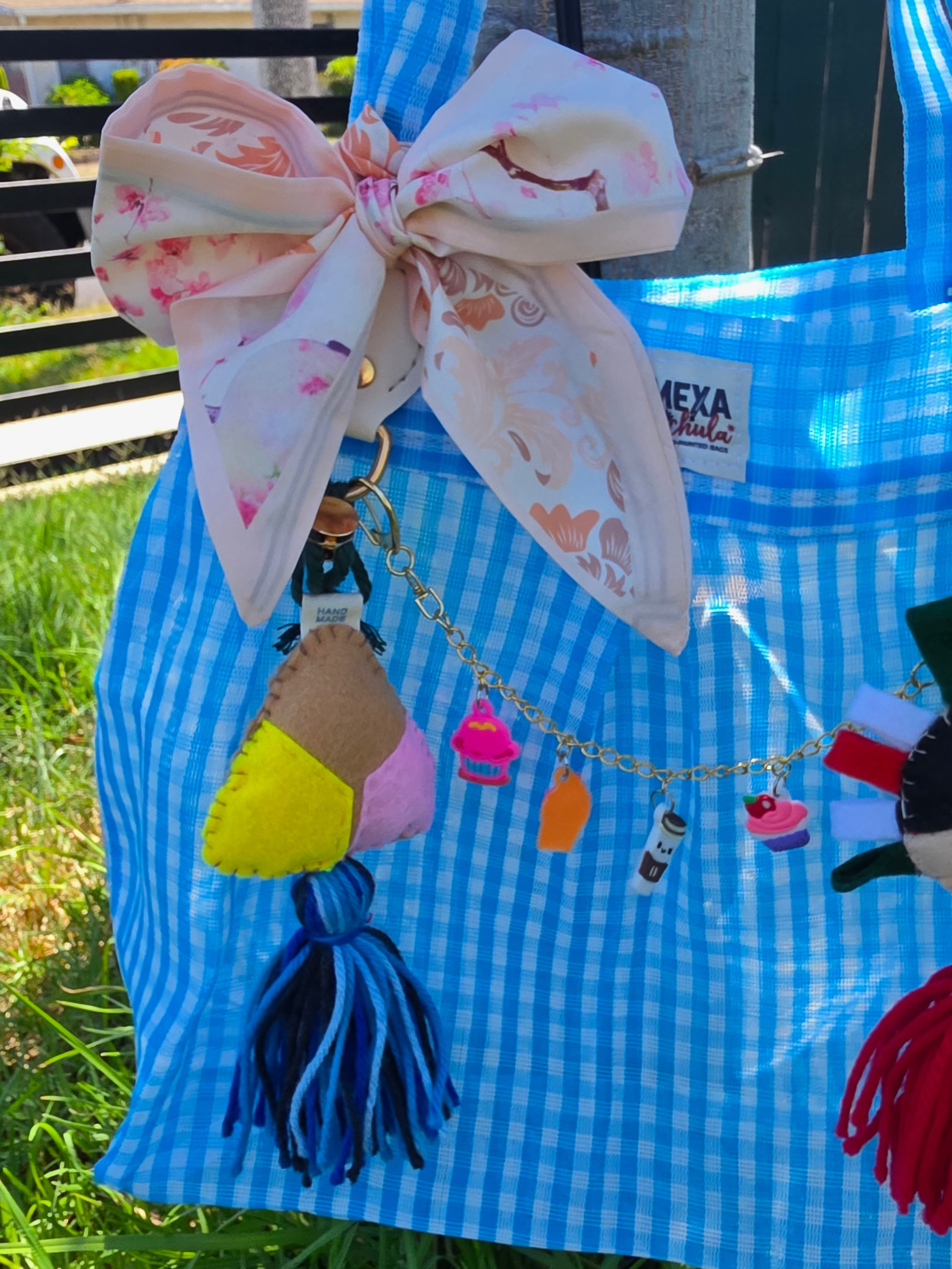 Bolsa de mercado mexicana con charm de concha de fieltro y cadena de dulces charms colgada al aire libre