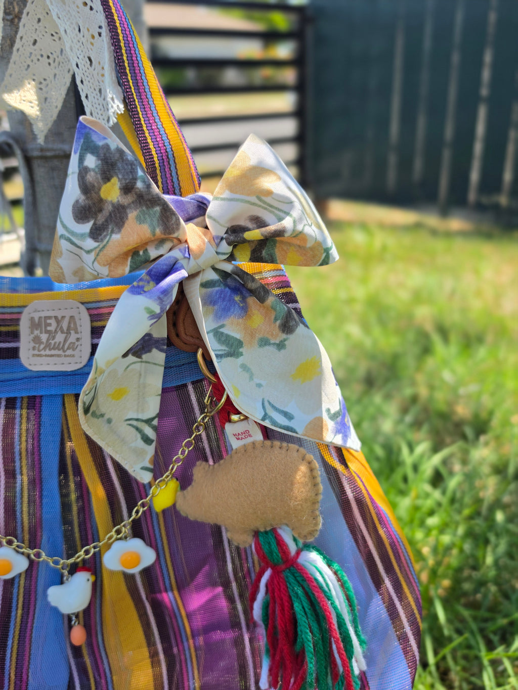 Detalle del moño floral y charms de Frida y cerdito en bolsa de mercado mexicana hecha a mano