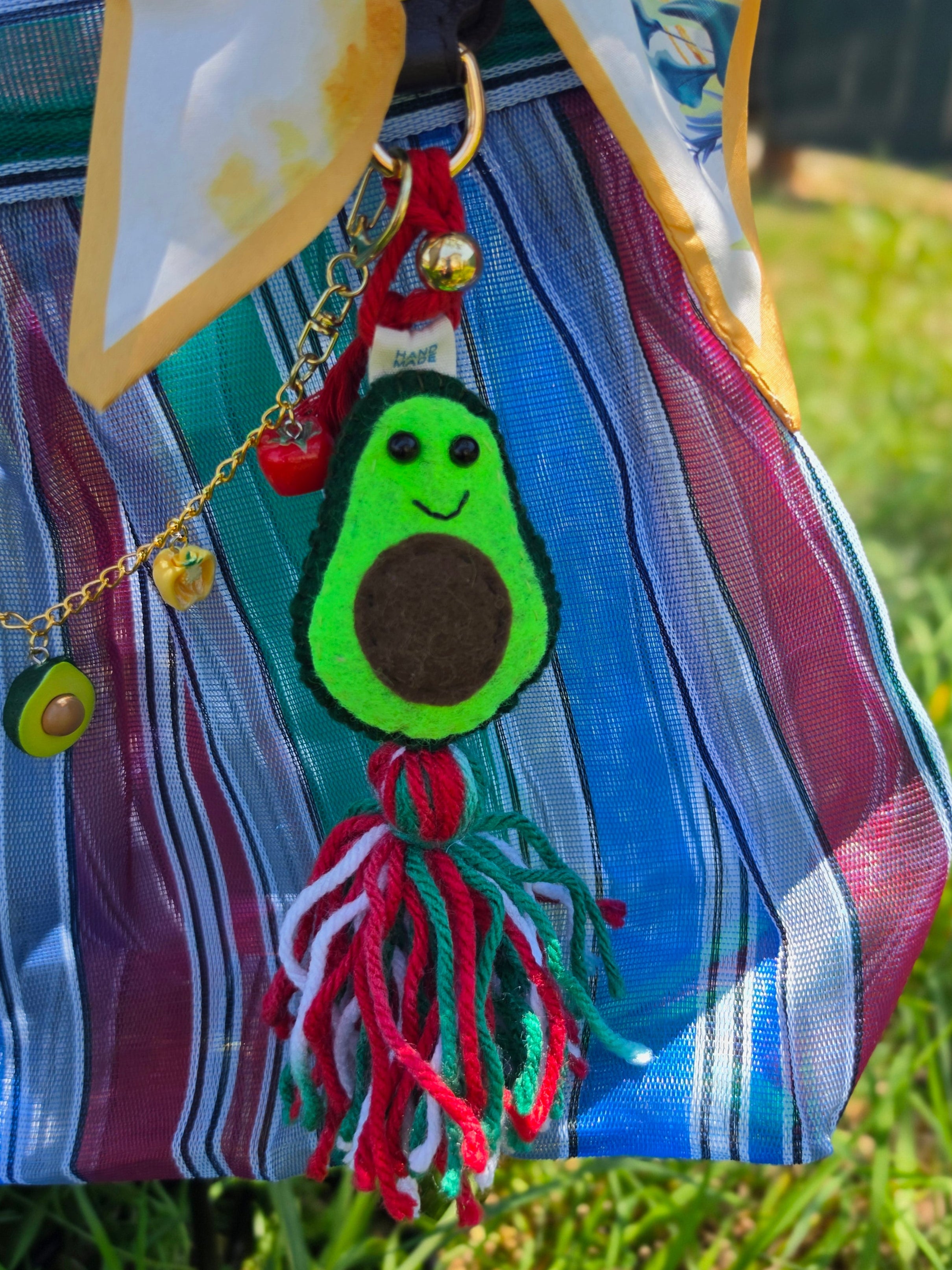 Charm de aguacate de fieltro con borla tricolor y cadena de dijes de chile y elote en bolsa de mercado mexicana