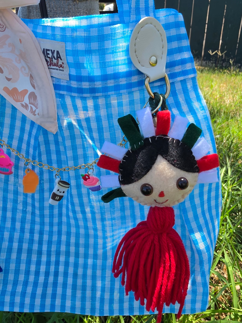 Bolsa de mercado mexicana a cuadros azul y blanco con charm de muñequita de fieltro con penacho tricolor